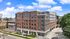Modern apartment building with brick facade and spacious outdoor area, showcasing urban living with convenient amenities at Legacy 202.