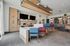 Modern communal lounge featuring stylish seating, elegant wooden cabinetry, and vibrant decor, perfect for socializing or relaxation.
