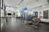 Modern gym with sleek fitness equipment, vibrant blue accents, and large mirrors providing a spacious and motivating environment.