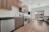 Modern kitchen and living area with sleek cabinets, stainless steel appliances, and large windows offering natural light.