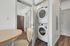Modern apartment with stylish in-unit washer and dryer, featuring sleek wood flooring and a cozy dining area.