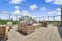 Luxurious rooftop patio with elegant wicker seating, offering stunning city views and vibrant atmosphere.