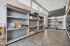 Modern package room with sleek shelving, organized parcels, and high ceilings in a well-lit apartment building.