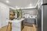 Modern kitchen featuring sleek grey cabinets, stainless steel appliances, and a stylish island with a cozy seating area.