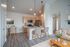 Contemporary open-concept kitchen and living area featuring sleek cabinetry, stylish wicker chairs, and modern lighting in a cozy apartment setting.