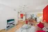 Vibrant living room with sleek hardwood floors, stylish glass coffee table, and cozy seating, featuring a modern dining area and open kitchen layout.