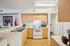 Inviting kitchen with modern appliances, light wood cabinets, and sleek countertops, accented by stylish decor and warm lighting.