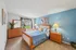 Bright and inviting bedroom with stylish wood furniture, calming blue accents, and natural light through a large window.
