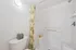Bright, modern bathroom featuring a stylish shower curtain with tropical pattern, sleek white tiles, and charming decor accents. Perfect for a relaxing, spa-like experience at home.