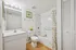 Bright and inviting bathroom featuring modern fixtures, elegant framed art, and a relaxing bathtub with a stylish shower curtain.
