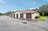 Charming apartment complex showcasing neatly arranged garages with red roofs, set amidst lush greenery and a peaceful environment.