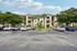 Charming apartment complex with stylish balconies, lush palm trees, and convenient parking, perfect for vibrant living.