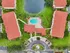 Stunning aerial view of a luxury apartment complex featuring red-roofed buildings, a sparkling pool, and lush green landscapes around a tranquil pond.