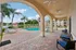 Inviting poolside oasis featuring elegant arches, lush palm trees, and comfortable lounge chairs, ideal for relaxation and enjoyment.