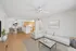 Elegant open-concept living area with sleek modern furniture, a cozy dining nook, and a stylish kitchen with wood cabinetry.