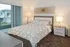 Cozy bedroom with modern decor featuring a stylish double bed, elegant lamps, and a private balcony view.