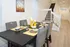 Charming dining area set with elegant tableware, complemented by contemporary gray chairs and a modern staircase backdrop.