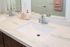 Elegant bathroom vanity with marble countertop, modern fixtures, and stylish mirror reflecting high-end design.