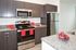 Modern kitchen with sleek granite countertops, stainless steel appliances, and rich wood cabinetry for a polished, contemporary look.