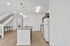Modern kitchen with sleek granite countertops, elegant pendant lighting, and an open staircase, embodying contemporary design and style.