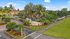 Inviting entrance to The Enclave Rental Townhomes surrounded by lush palm trees and vibrant landscaping, offering a serene and picturesque community setting.