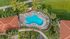 Lush aerial view of a stunning tropical oasis featuring a vibrant blue swimming pool, surrounded by elegant loungers, palm trees, and inviting pathways.