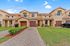 Charming townhouse featuring a modern design with brick driveways, manicured lawns, and inviting entryways in a serene neighborhood setting.