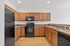 Modern kitchen with sleek black appliances, rich wooden cabinets, and spacious countertops.