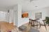 Charming open-plan dining and kitchen area with elegant wooden furnishings and modern decor. Bright and inviting ambience, perfect for cozy gatherings.