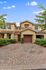 Charming townhouse with a tiled roof and vibrant landscaping, featuring a wide driveway and welcoming entrance.