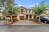 Charming townhouse with a beautiful brick driveway, flourishing garden, and lush trees, perfect for stylish suburban living.