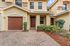 Charming townhouse exterior with elegant archways, lush landscaping, and a welcoming entrance.