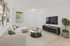 Elegant living room with chic beige sectional, stylish wall art, and lush greenery, featuring a modern entertainment setup and inviting natural light.