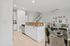 Elegant open-concept kitchen and living area featuring a chic breakfast bar, sophisticated dining set, and cozy seating corner.