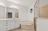 Elegant bathroom with a spacious corner bathtub, sleek double sink vanity, and bright lighting, perfect for relaxation.
