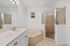 Elegant bathroom with a luxurious bathtub, sleek countertop, and modern glass shower enclosure.