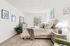 Charming bedroom with stylish decor, lush greenery, and ample natural light creating a serene retreat.