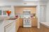 Charming kitchen with light wood cabinets, modern appliances, and vibrant decor accents for a warm, inviting atmosphere.