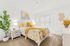 Elegant bedroom with bright yellow accents, featuring a plush bed, modern nightstand, and vibrant indoor plant.