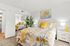 Bright and inviting bedroom with floral bedding, vibrant yellow accents, and a mirrored closet reflecting natural light.