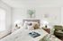 Inviting bedroom featuring a plush bed with elegant patterned bedding, accented by soft lighting from stylish lamps and tasteful wall art, promoting a cozy and tranquil atmosphere.