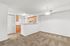 Inviting open-concept living area with plush carpeting and a modern kitchen featuring sleek cabinetry.