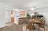 Charming apartment interior featuring a cozy dining area with stylish wooden furniture, a vibrant plant, and a welcoming kitchen with modern amenities.