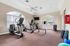 Bright and modern fitness center featuring cardio machines, free weights, and large windows for a refreshing workout experience.