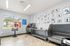 Bright and welcoming pet spa with stainless steel bathing stations, colorful animal artwork, and a view of lush greenery.