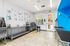 Bright pet grooming room featuring colorful animal artwork, sleek stainless steel fixtures, and vibrant blue accents, perfect for pet care.