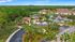 Aerial view of a serene apartment complex surrounded by lush greenery, featuring a central pool and scenic pond with fountain.
