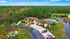 Charming aerial view of a luxurious apartment complex surrounded by lush greenery, featuring a sparkling pool and serene pond.