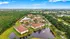 Scenic aerial view of a picturesque apartment community surrounded by lush greenery and tranquil ponds.