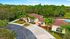 Charming residence with palm-lined drive, surrounded by lush greenery, featuring inviting pool and ample seating for relaxation.